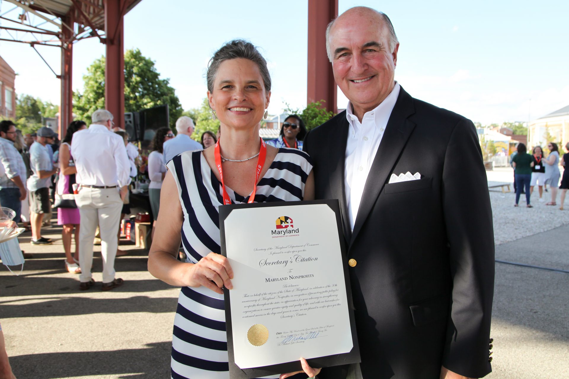 Heather Iliff and Secretary of Commerce Mike Gill pose with a Citation awarded to Maryland Nonprofits