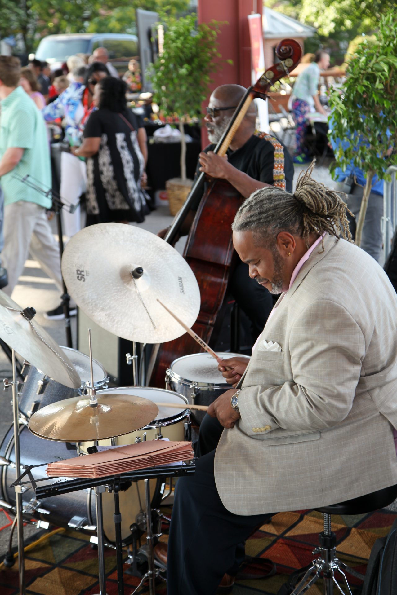 Members of a live band play the drums and upright bass