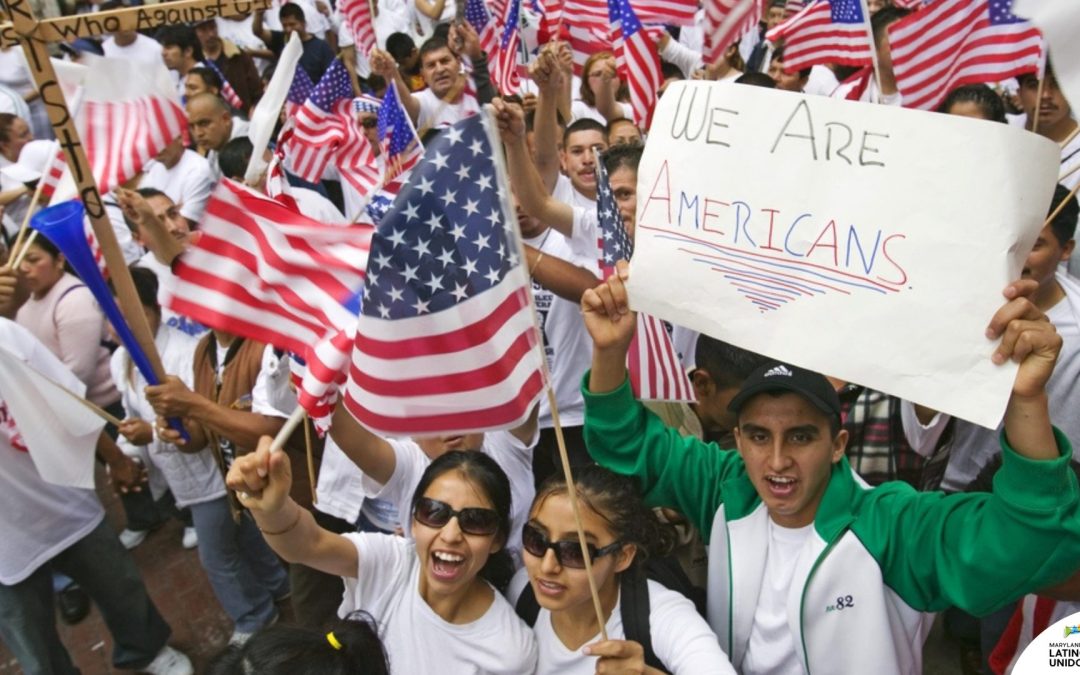 Latinos marching with signs of "We are Americans"
