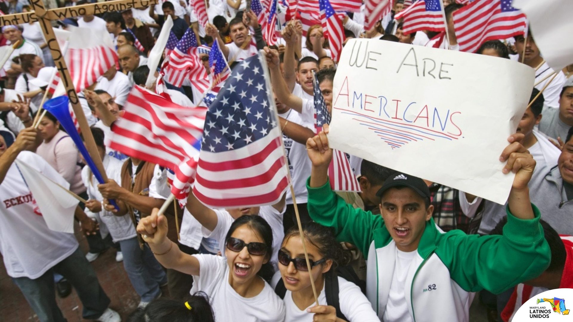 Latinos marching with signs of "We are Americans"